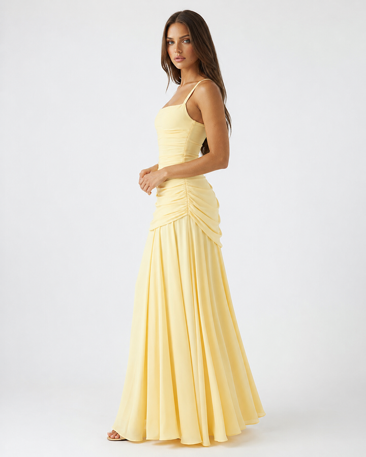 Vue de profil de la robe jaune pâle, montrant le froncé du côté de la taille et la jupe ample en chiffon. 3