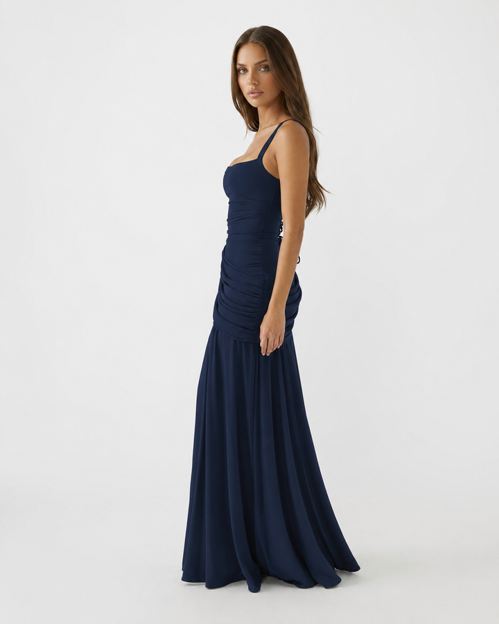 Robe bleu marine vue de profil, taille ajustée, plissés sur la hanche et jupe évasée. 7