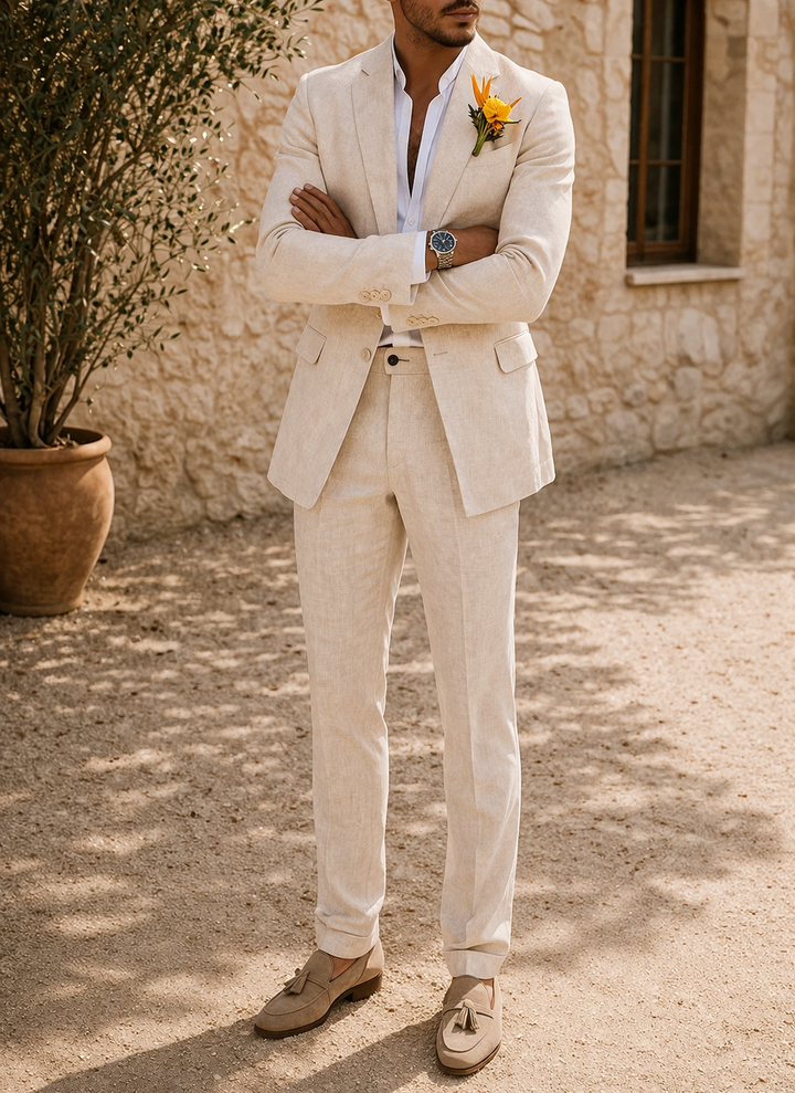 Version beige clair du costume porté par un homme, bras croisés, chemise blanche, boutonnière jaune et mocassins en daim à pampilles. 3