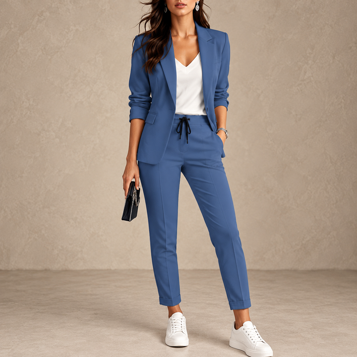 Femme en ensemble bleu avec top blanc, baskets blanches et pochette noire, pantalon à cordon 1