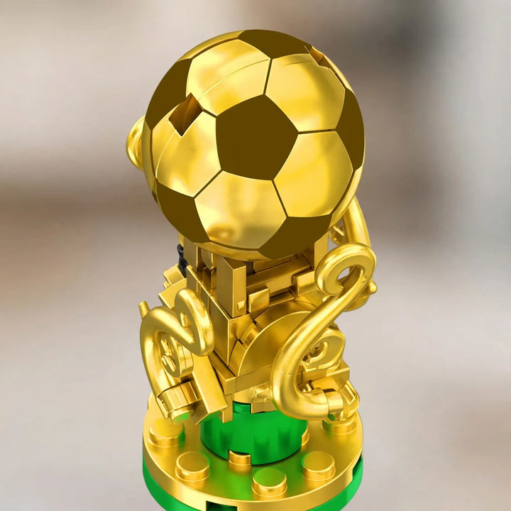 Gros plan sur le trophée doré à ballon de football, construit en briques sur socle vert 3