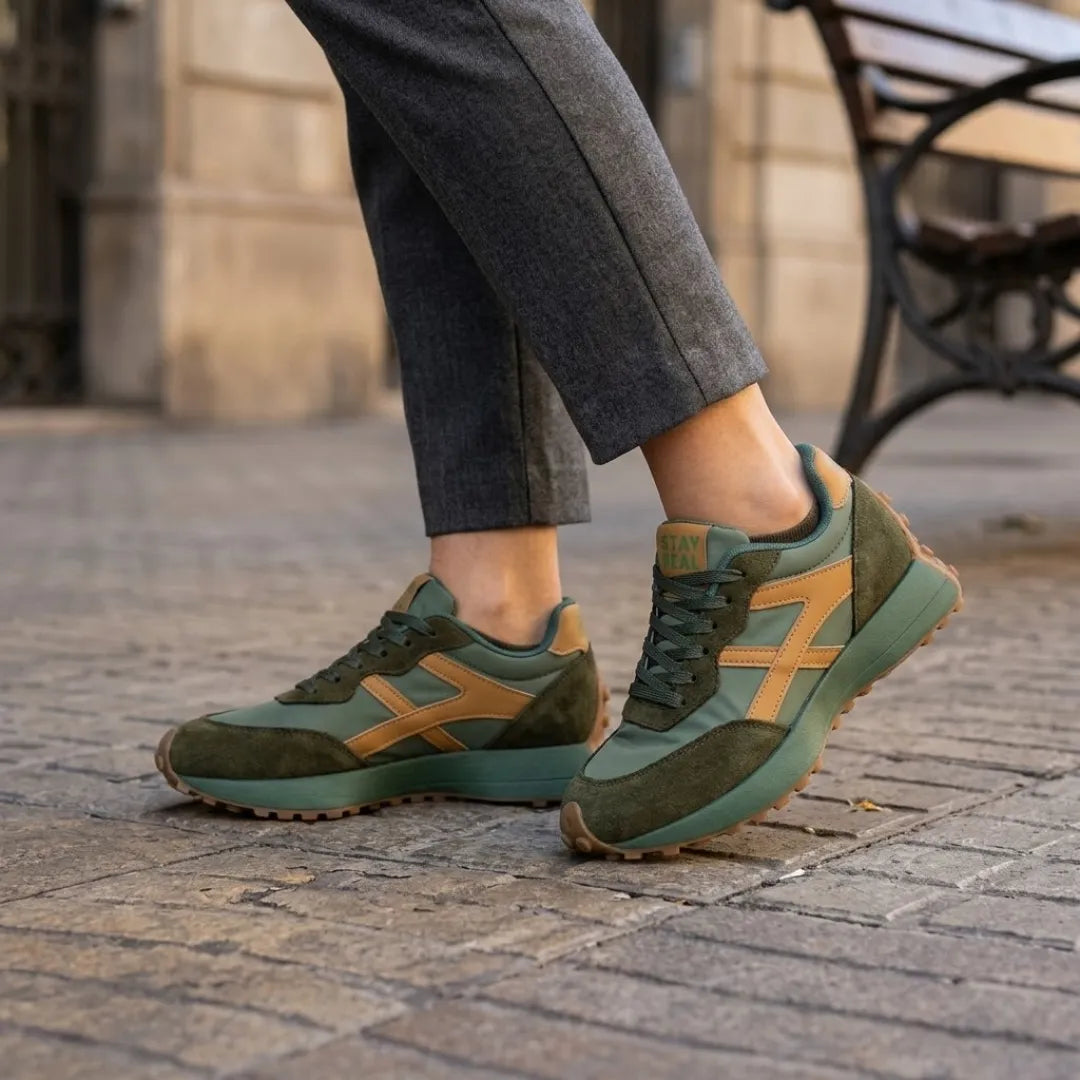 Baskets vertes à bandes camel portées avec un pantalon gris près d'un banc 12