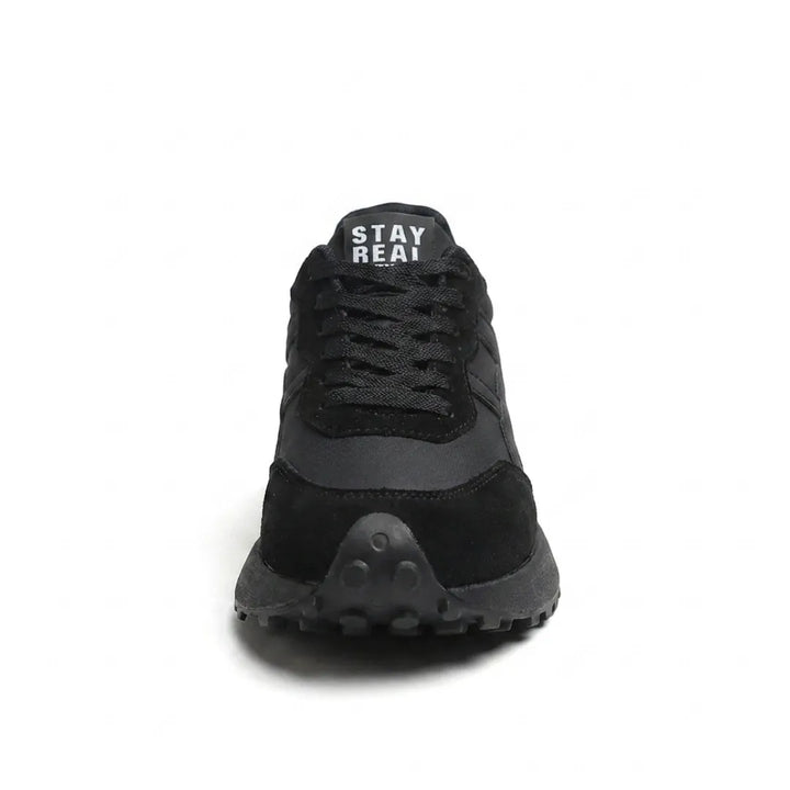 Vue de face de la basket noire, lacets, bout en daim et semelle crantée noire 9