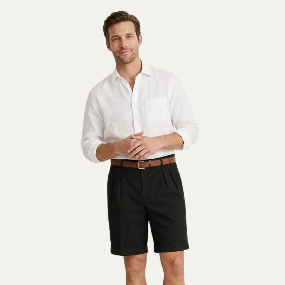 Mannequin en short noir à plis, chemise blanche à manches retroussées et ceinture marron, mains jointes devant lui. 10