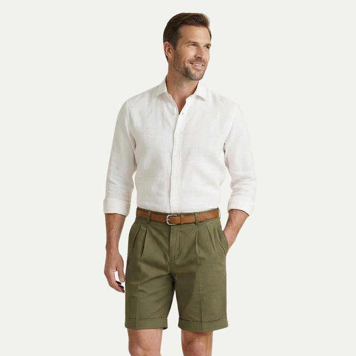 Mannequin en short vert olive à plis, chemise blanche manches retroussées et ceinture marron, main dans la poche. 12