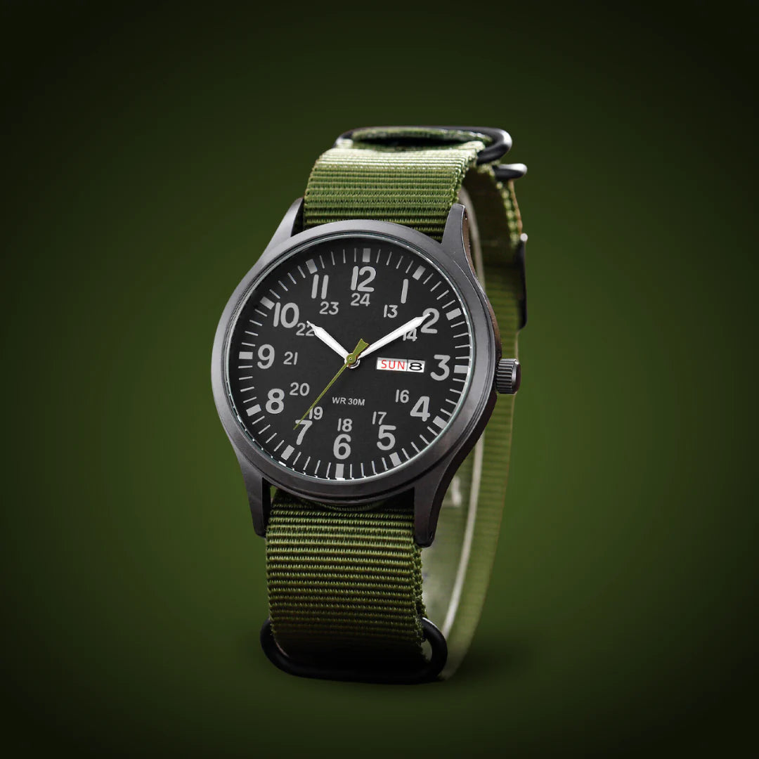 Montre posée en trois quarts sur un fond vert sombre, montrant le boîtier noir, la couronne et le bracelet tissé. 4