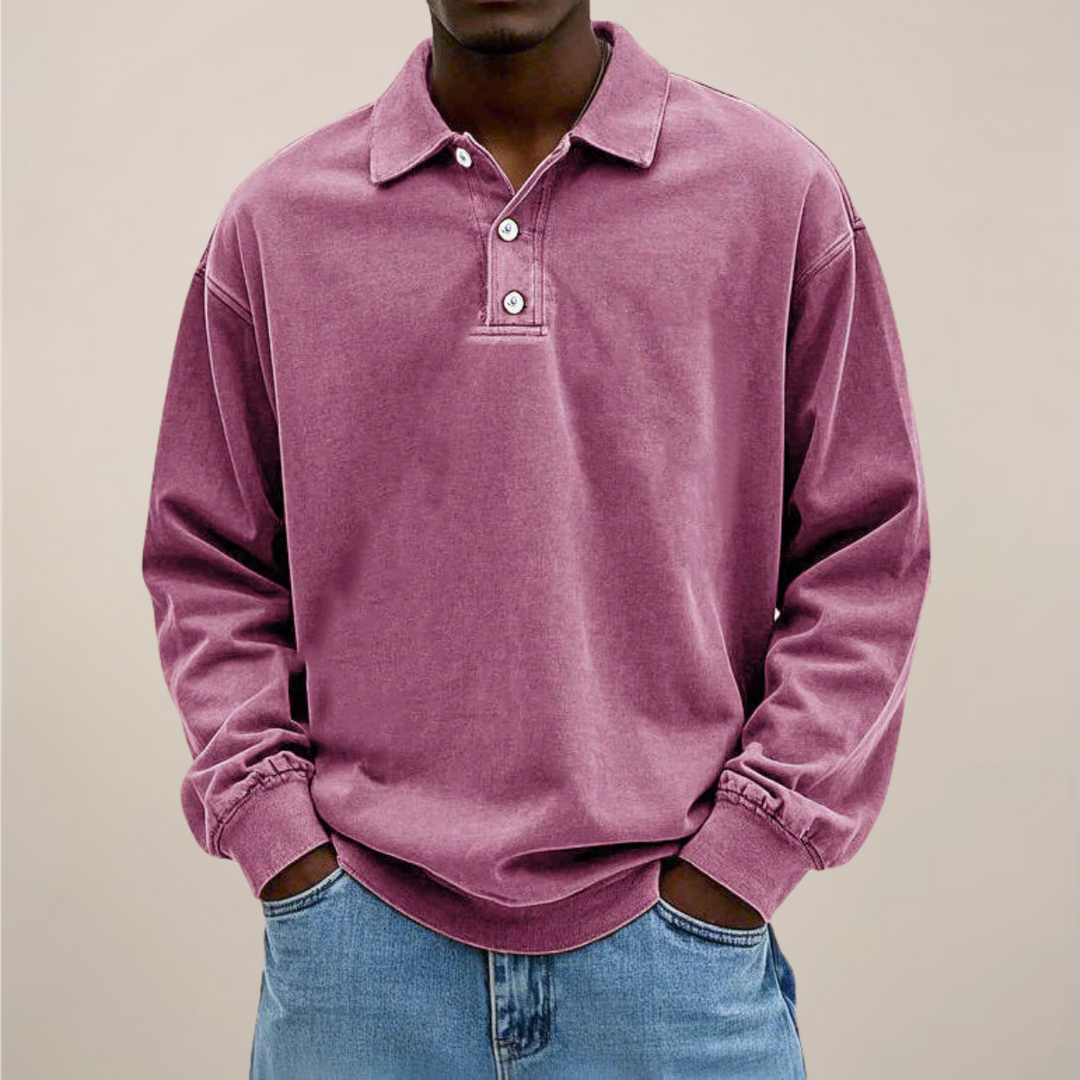 Polo rose mauve porté par un homme, mains dans les poches d'un jean clair, vue de face. 10