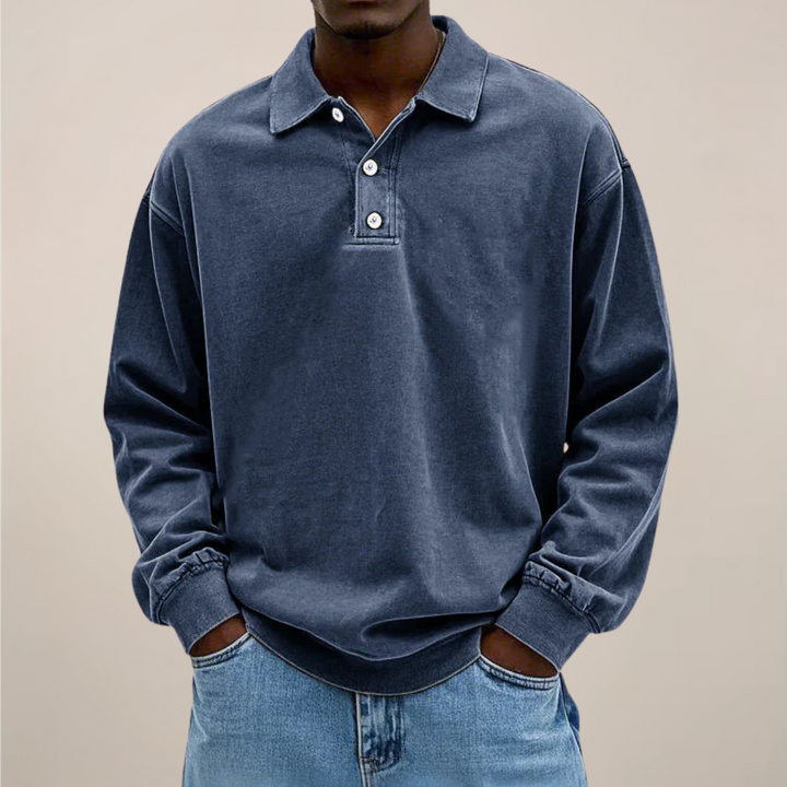 Polo bleu marine grisé porté par un homme, mains dans les poches d'un jean clair, vue de face. 5