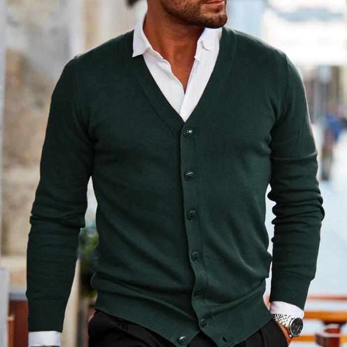 Cardigan vert foncé boutonné, porté sur une chemise blanche au col ouvert, avec montre et poignets côtelés visibles. 3