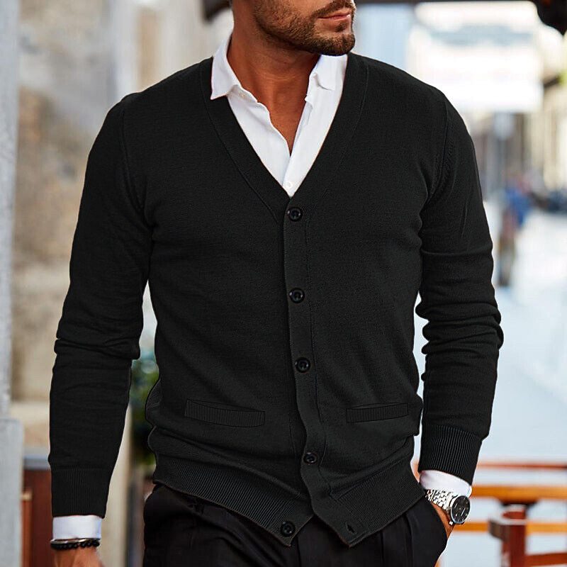 Cardigan noir porté sur une chemise blanche, avec deux poches plaquées à la taille et boutons sur le devant. 5