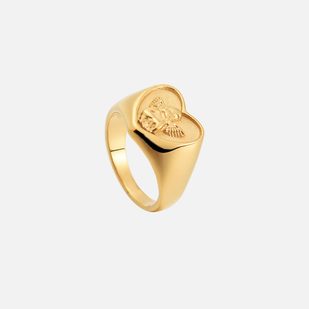 Bague chevalière dorée à plateau en cœur avec ange en relief, vue de dessus penchée montrant l'intérieur de l'anneau. 2