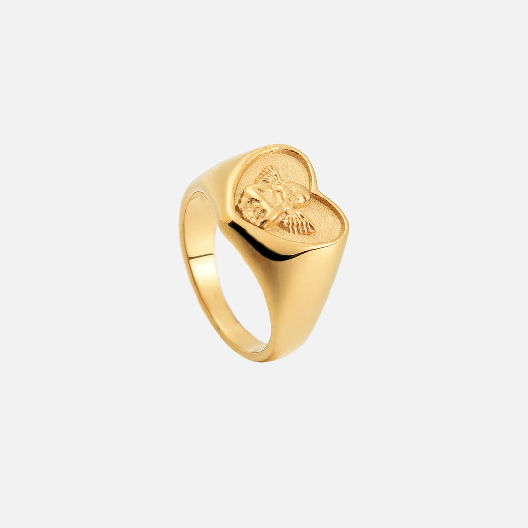 Bague chevalière dorée à plateau en cœur avec ange en relief, vue de dessus penchée montrant l'intérieur de l'anneau. 2