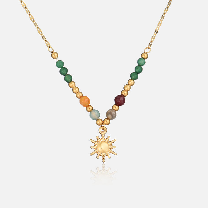 Collier doré vu de face sur fond clair, perles vertes, orange et bordeaux, soleil central 1