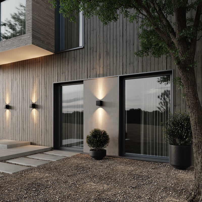 Appliques cubiques noires allumées en extérieur au crépuscule sur une façade en bois, éclairant le mur de haut en bas. 3