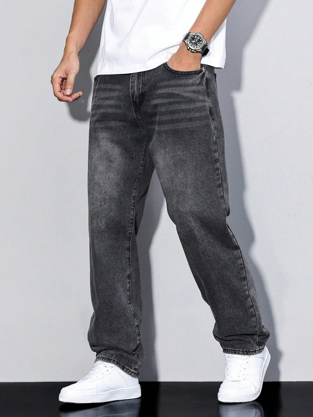 Jean gris foncé délavé porté en vue de face, main dans la poche, avec t-shirt blanc et baskets blanches. 10