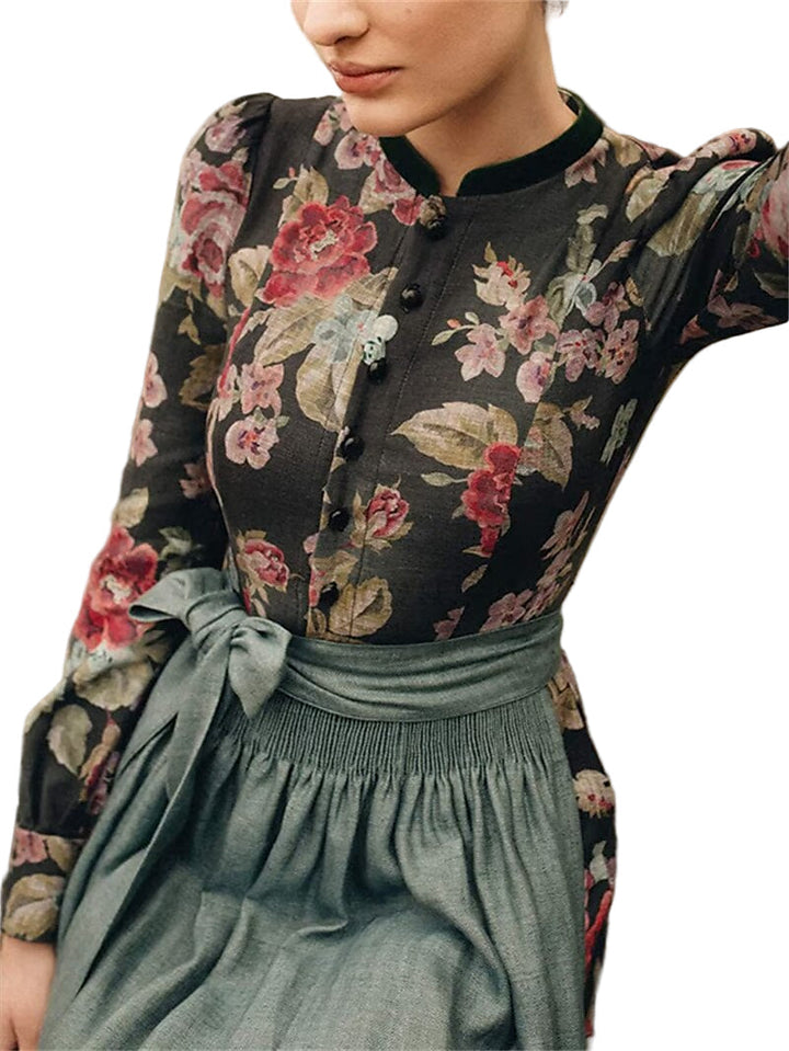 Buste porté par une mannequin : corsage fleuri boutonné, col montant bordé de vert et tablier gris-vert noué à la taille. 2