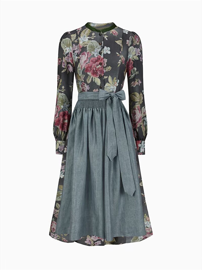 Vue de face de la robe florale à col montant avec tablier gris-bleu noué par un grand nœud, sur fond blanc. 1