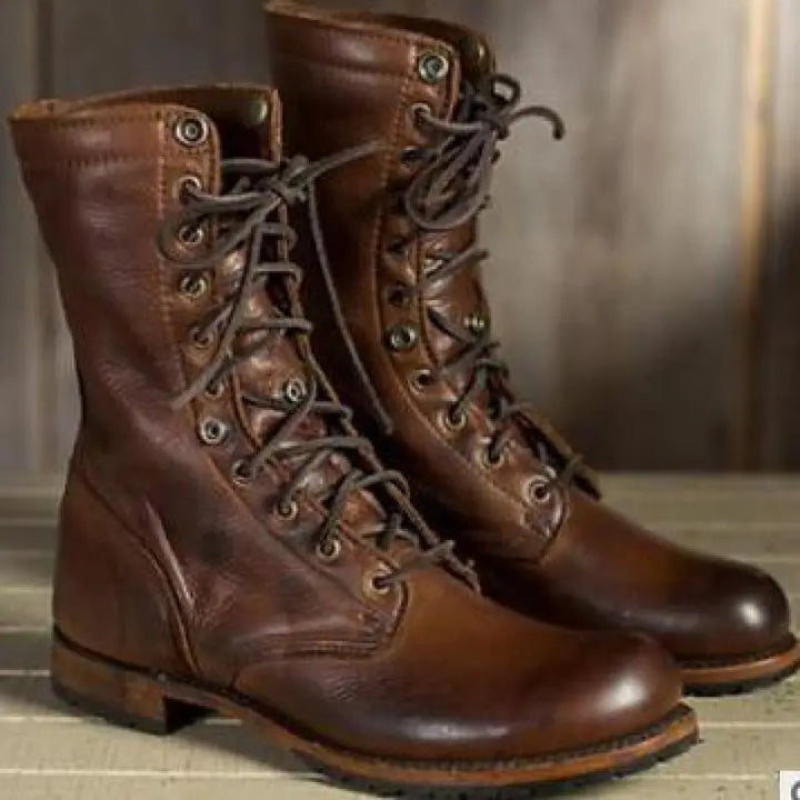 Paire de bottes montantes en cuir brun, vue de trois quarts avec lacets foncés, œillets métalliques et semelle épaisse crantée. 1