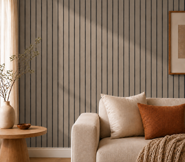 Gros plan sur mur de lattes gris-brun à rainures noires, canapé beige et coussin orange 26