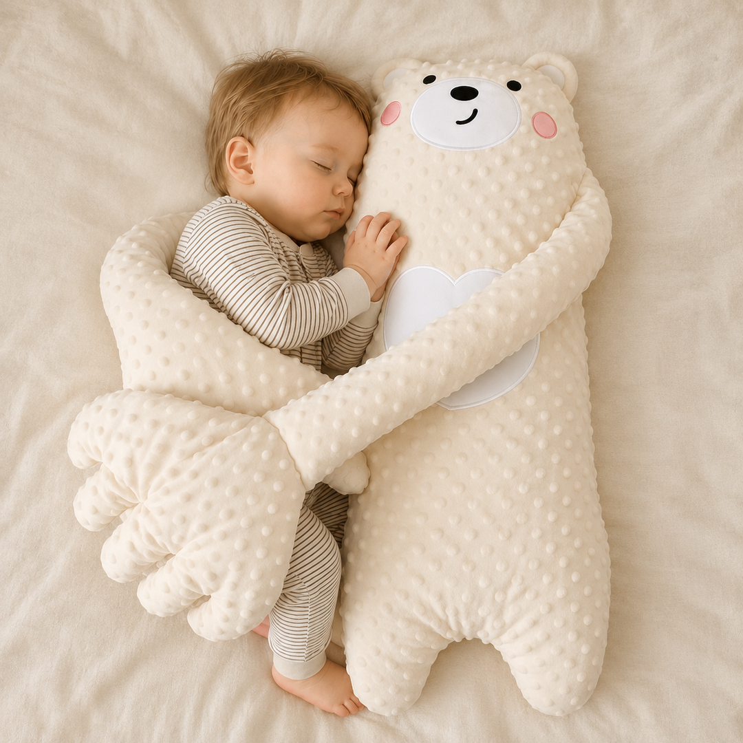 Bébé endormi en pyjama rayé, blotti contre une grande peluche ourson crème en tissu à bulles, ses longs bras autour de lui. 1