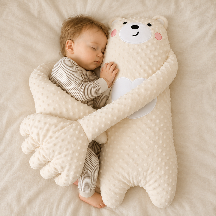 Bébé endormi en pyjama rayé, blotti contre une grande peluche ourson crème en tissu à bulles, ses longs bras autour de lui. 1