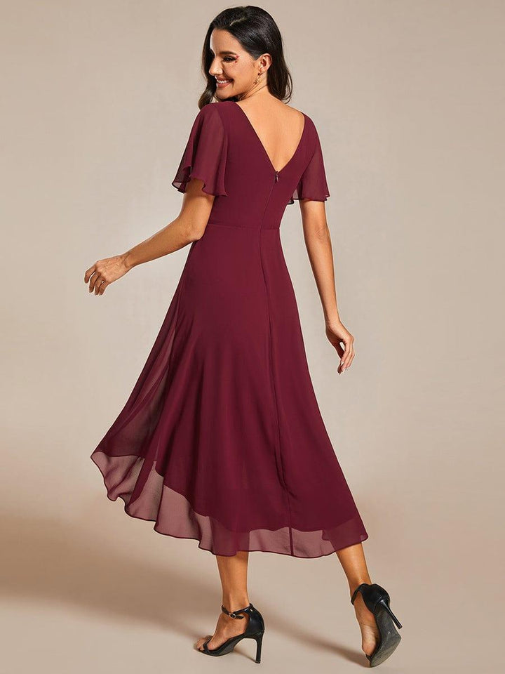 Vue de dos de la robe bordeaux, dos échancré en V, zip central et jupe asymétrique qui flotte. 4