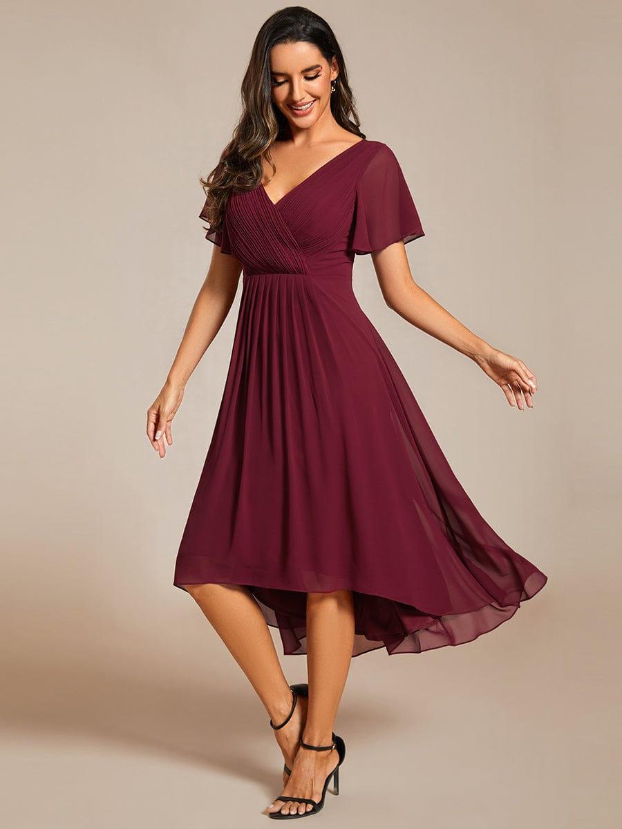 Robe bordeaux en mousseline portée avec des sandales noires, mannequin en mouvement, ourlet asymétrique et manches courtes évasées. 47