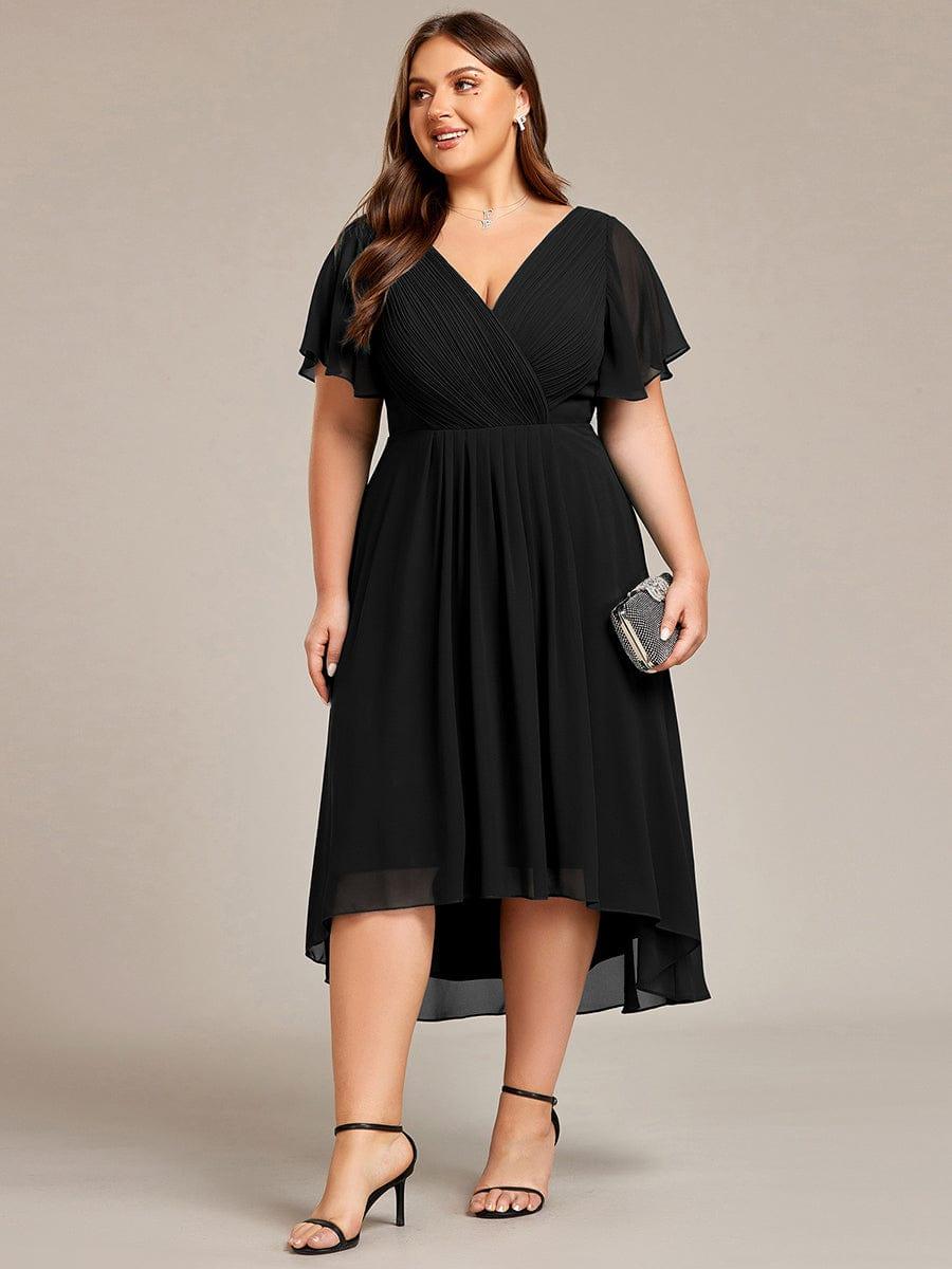 Robe noire grande taille portée de face, mannequin tenant une pochette scintillante, ourlet asymétrique plus long derrière. 30