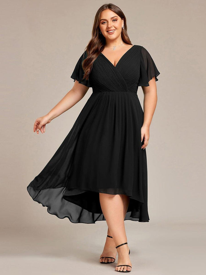 Robe noire grande taille portée de face par une mannequin, jupe fluide en mousseline à ourlet asymétrique en mouvement. 26