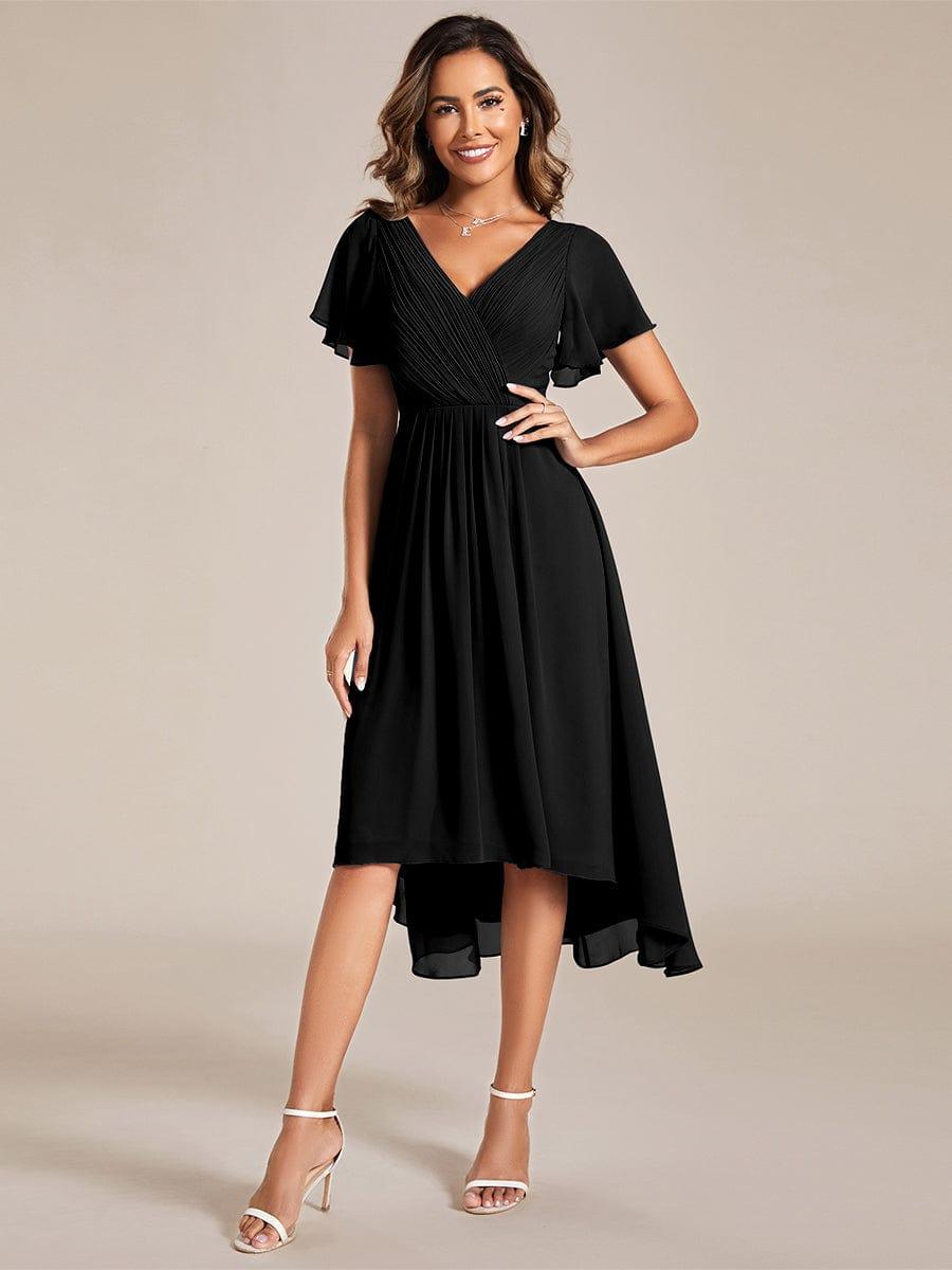 Robe noire en mousseline portée de face par une mannequin, col en V plissé, manches volantées et ourlet asymétrique. 21