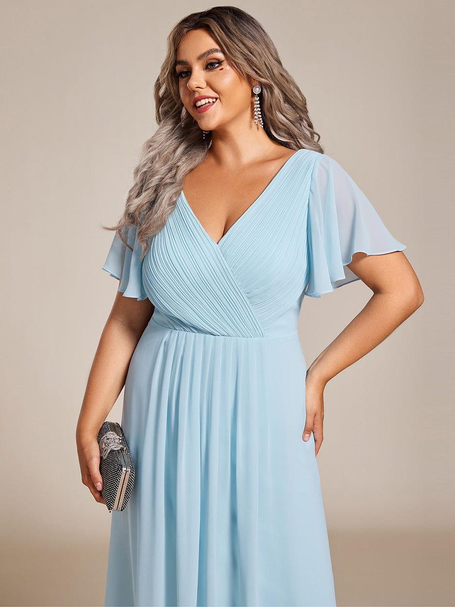 Gros plan sur le buste plissé de la robe bleu ciel, mannequin grande taille avec pochette et boucles d'oreilles pendantes 91