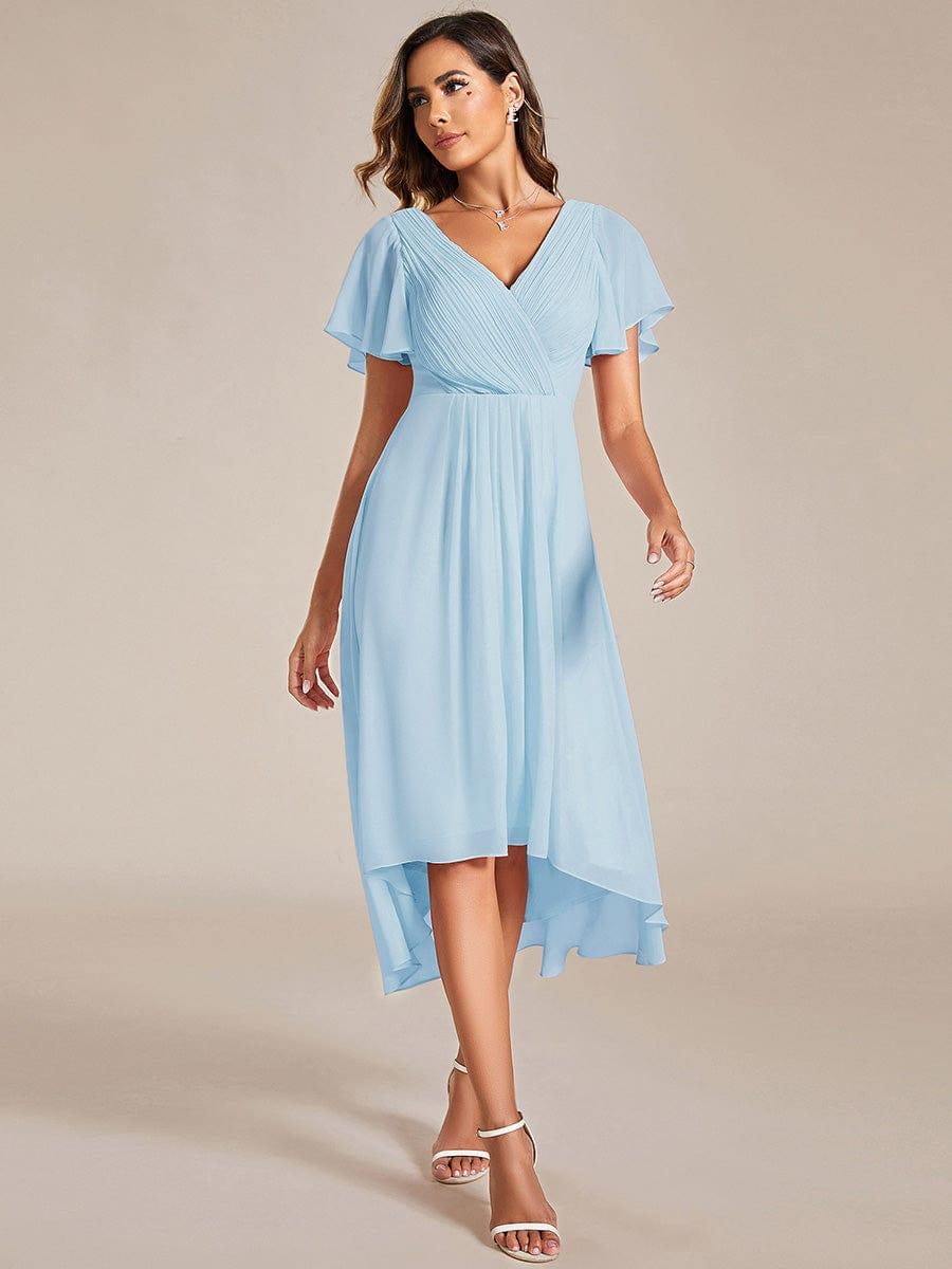 Robe bleu ciel portée de face par une mannequin, buste plissé croisé, manches volantées et ourlet asymétrique 84