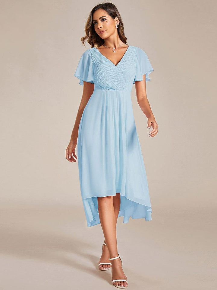 Robe bleu ciel portée de face par une mannequin, buste plissé croisé, manches volantées et ourlet asymétrique 84