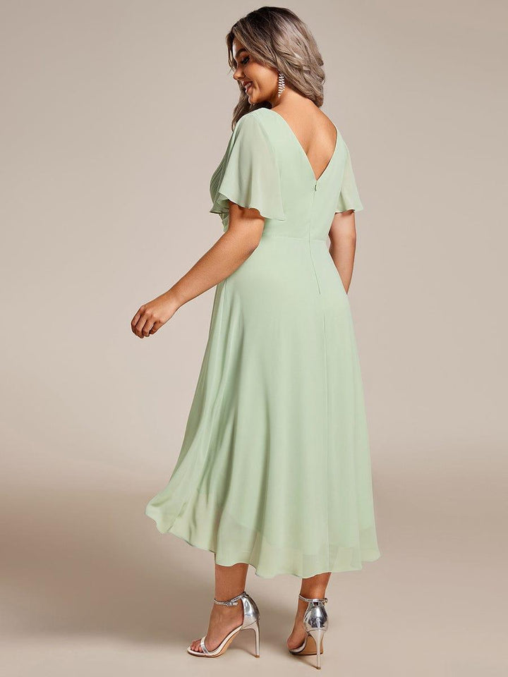 Vue de dos de la robe vert sauge, décolleté en V dans le dos, fermeture zippée et ourlet plus long derrière 82