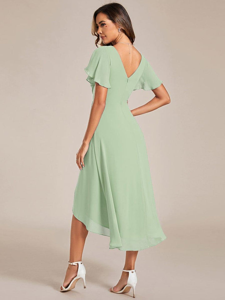 Vue de dos de la robe vert sauge, décolleté en V dans le dos avec zip, manches volantées et jupe plus longue derrière. 77
