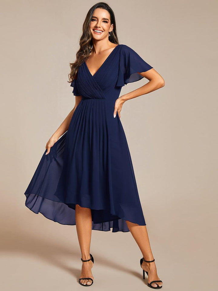 Mannequin en robe bleu marine, main sur la hanche, soulevant la jupe asymétrique en mousseline, vue de face. 54