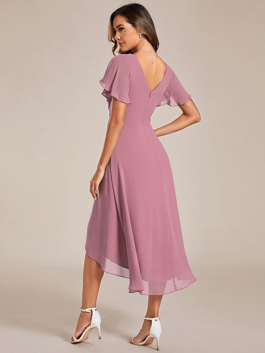 Vue de dos de la robe rose mauve sur mannequin, dos en V avec fermeture zippée, manches volantées et ourlet asymétrique. 59
