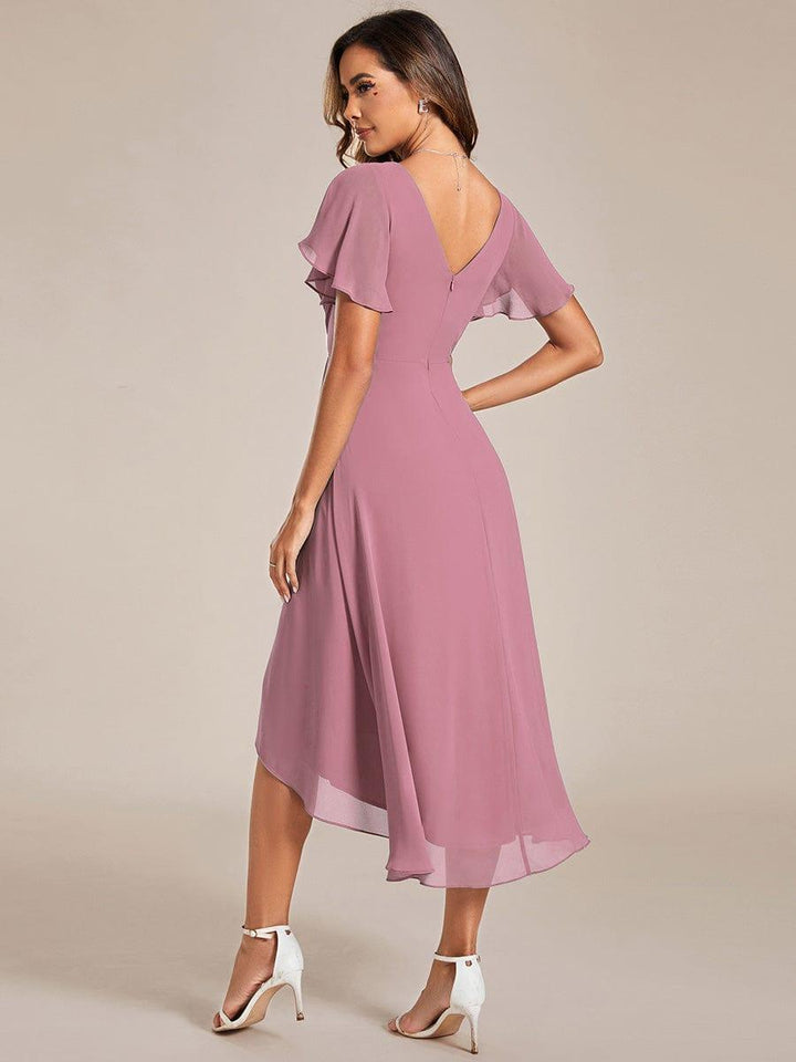Vue de dos de la robe rose mauve sur mannequin, dos en V avec fermeture zippée, manches volantées et ourlet asymétrique. 59