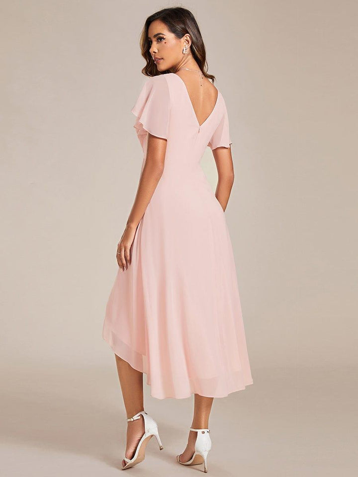Vue de dos de la robe rose pâle, dos en V avec zip, manches volantées et ourlet plus long derrière. 16