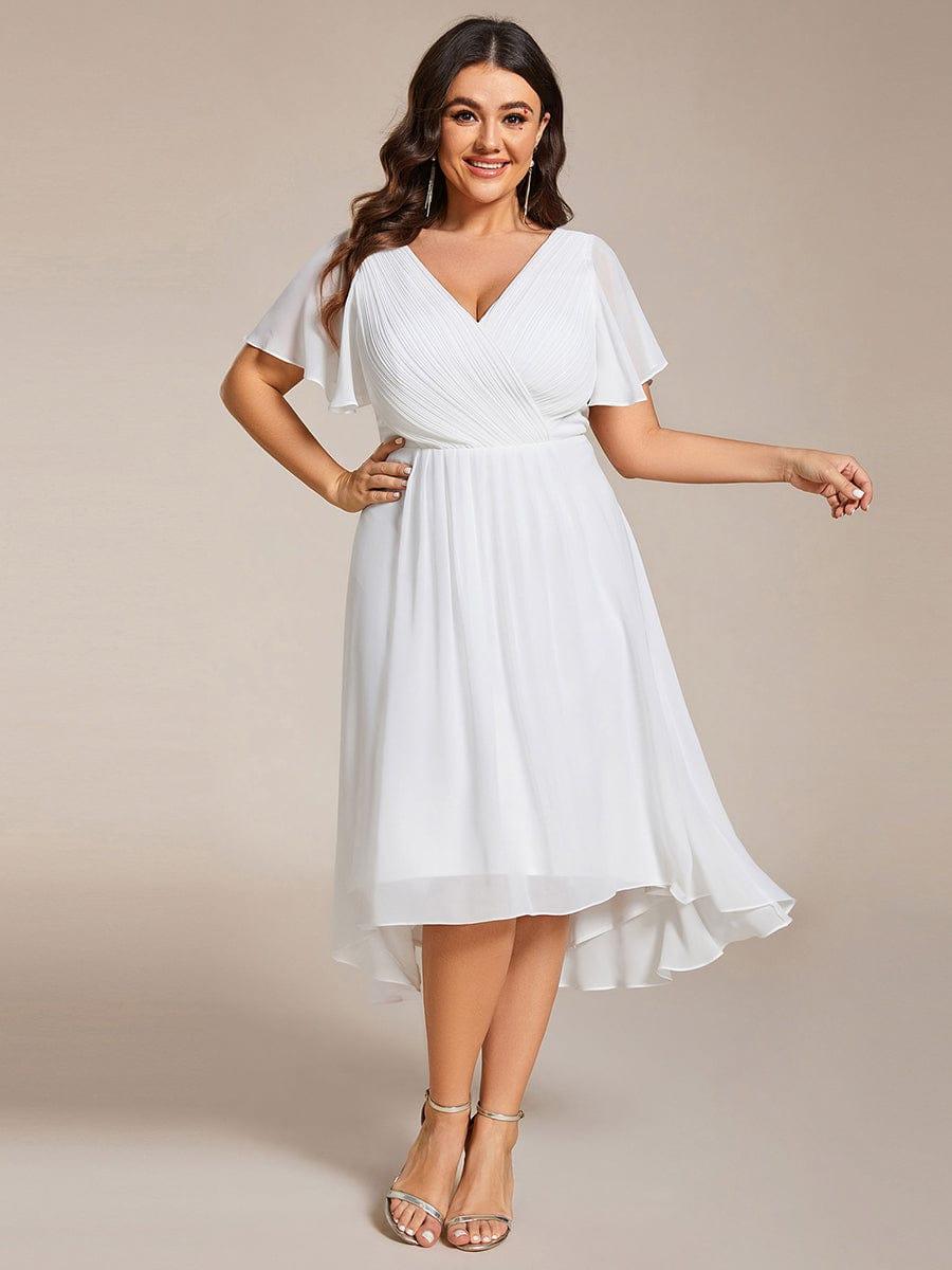 Robe blanche portée de face par une mannequin en grande taille, main sur la hanche, jupe fluide à ourlet asymétrique. 73