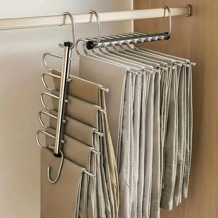 Deux organisateurs suspendus à une tringle d'armoire, l'un déplié à la verticale, l'autre replié, chargés de nombreux pantalons beiges. 1