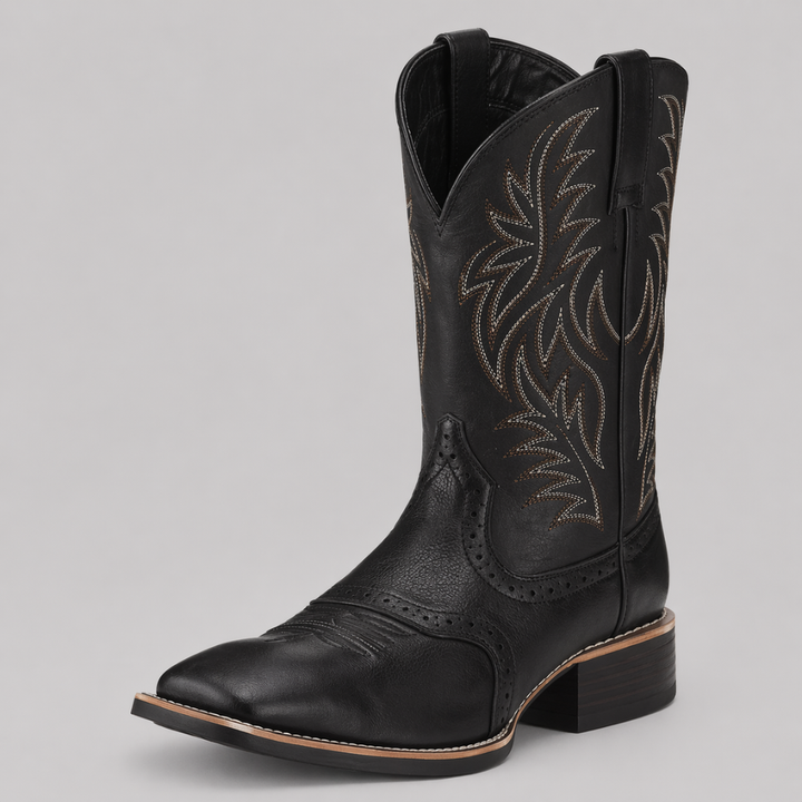 Botte de cowboy noire en vue trois-quarts, tige brodée de motifs blancs et bruns, talon bas 1