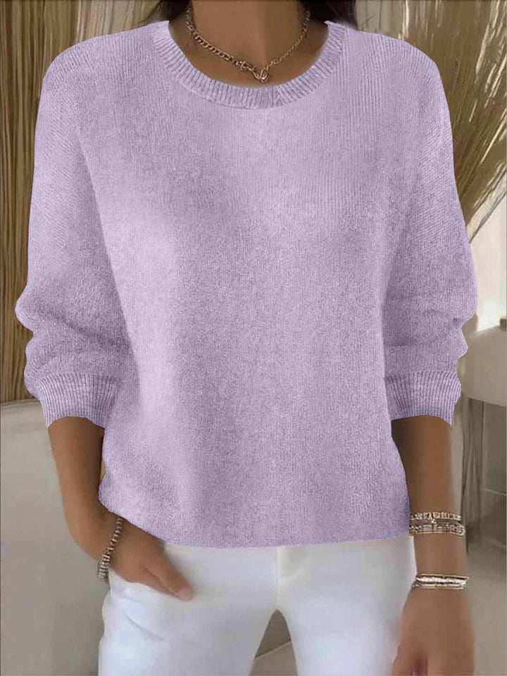 Pull lilas clair à col rond, porté avec un pantalon blanc et des bracelets 14