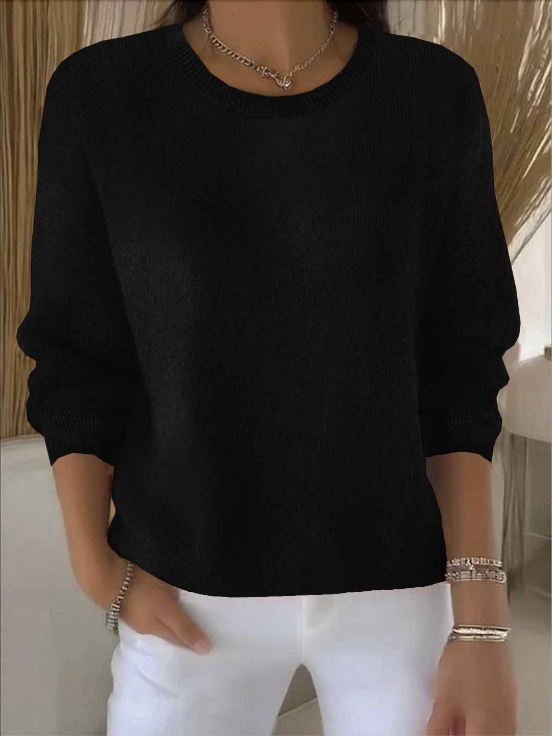 Pull noir à col rond et poignets côtelés, porté avec un pantalon blanc 7