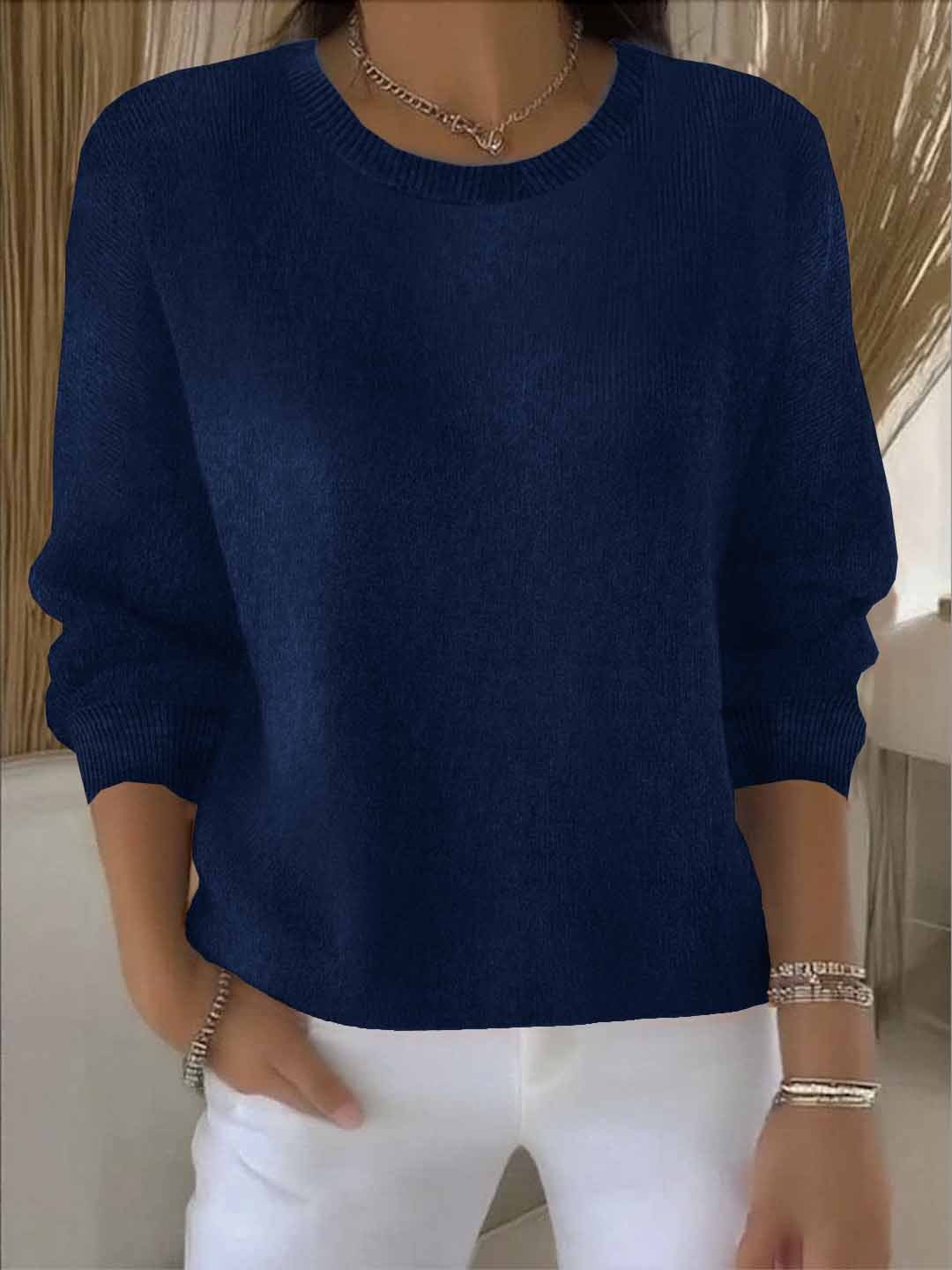 Pull bleu marine à col rond, porté avec un pantalon blanc et un collier 9