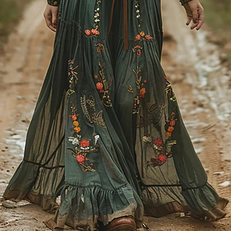 Gros plan sur la jupe verte ample et transparente, ornée de broderies florales et d'un volant 2
