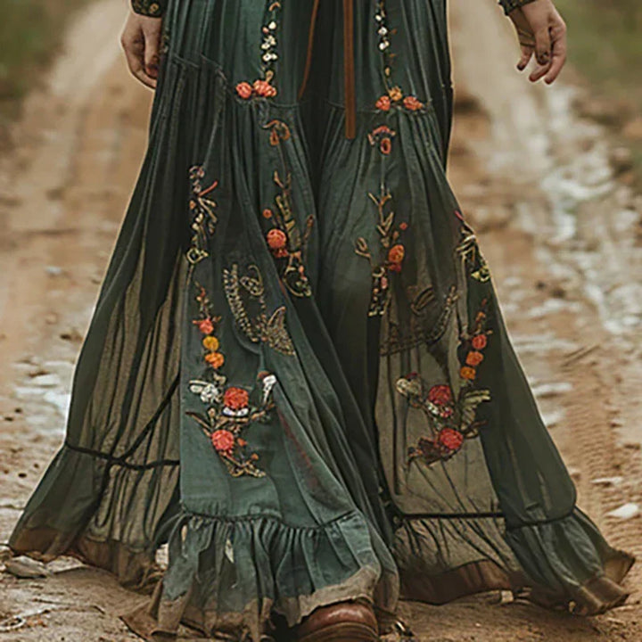 Gros plan sur la jupe verte ample et transparente, ornée de broderies florales et d'un volant 2