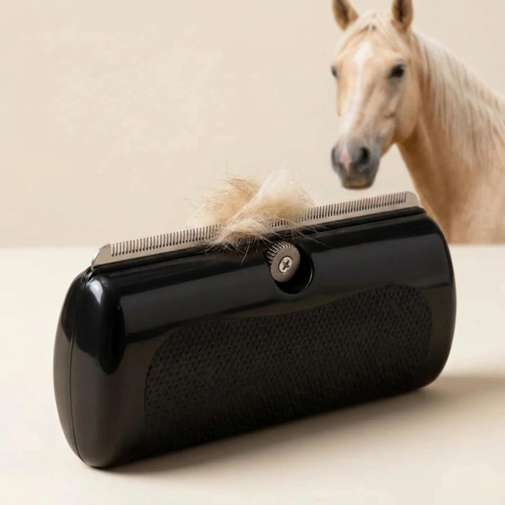 Brosse noire posée sur une table, une touffe de poils clairs coincée dans ses dents métalliques, avec un cheval crème en arrière-plan. 1