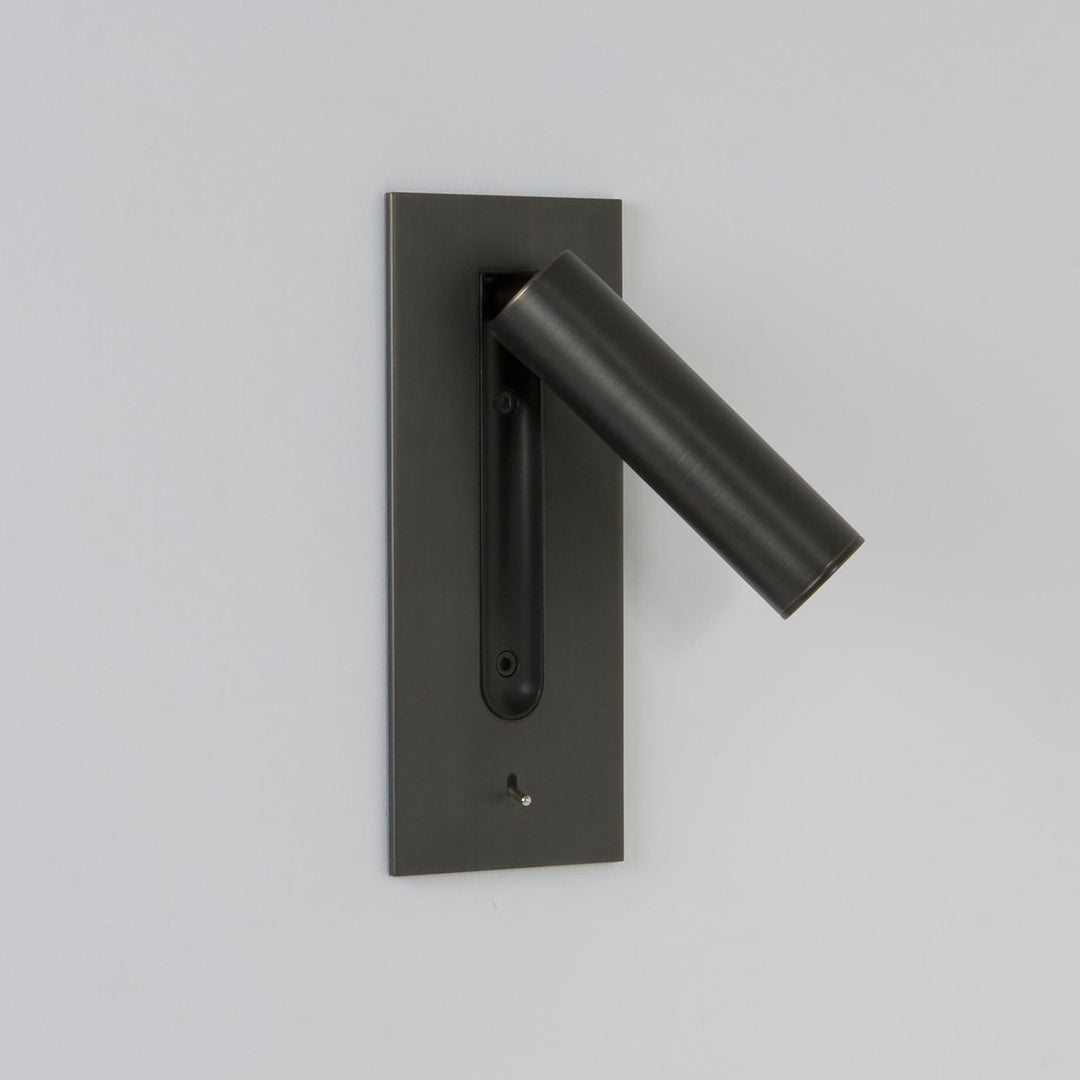 Applique sombre au tube relevé et incliné vers la droite, LED éteinte, mur gris clair 6