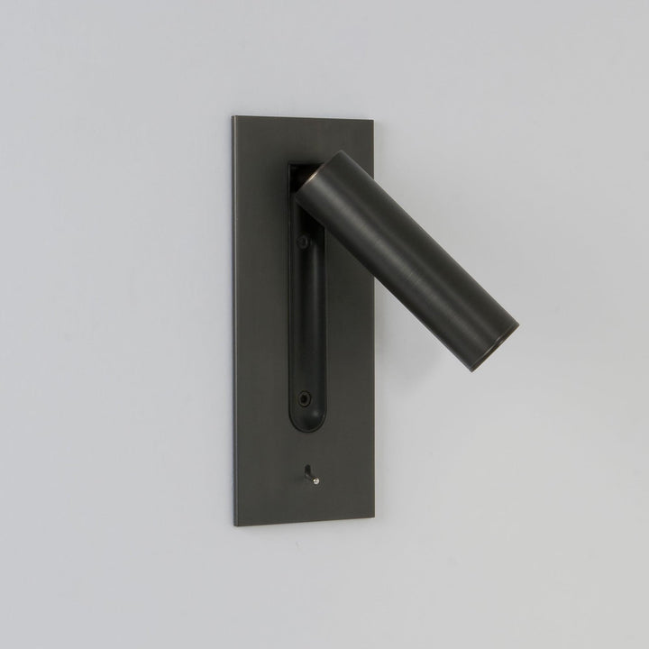 Applique sombre au tube relevé et incliné vers la droite, LED éteinte, mur gris clair 6